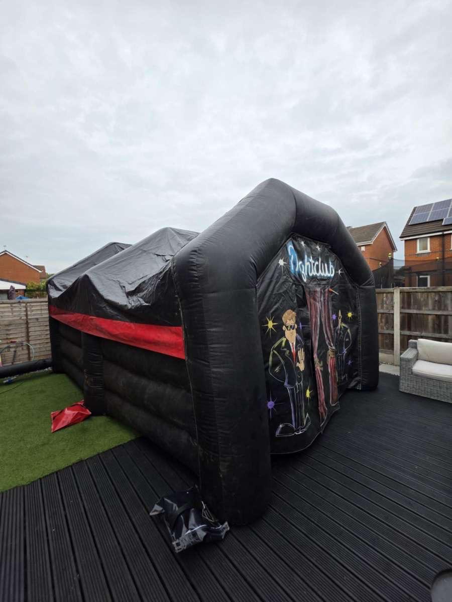 Inflatable night club hire installed in a garden with decking and artificial grass